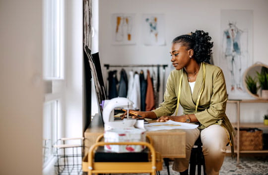 Clothing designer works on her laptop