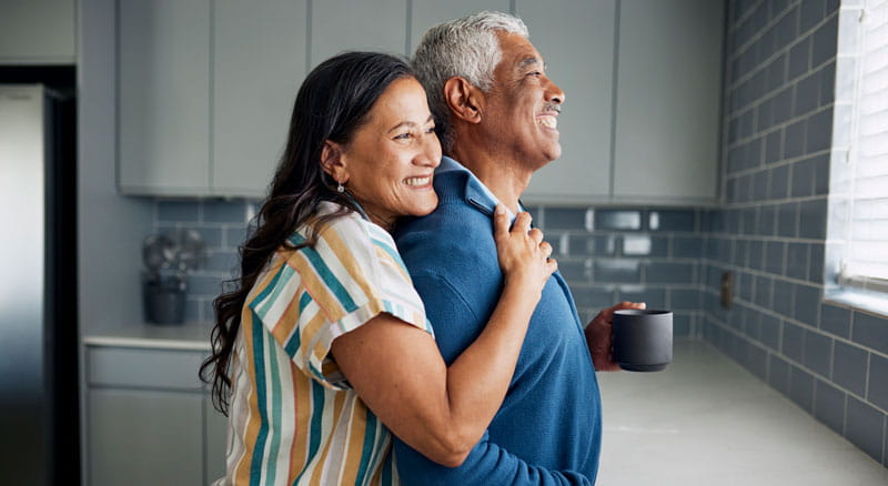 Happy older couple hugging while looking out window