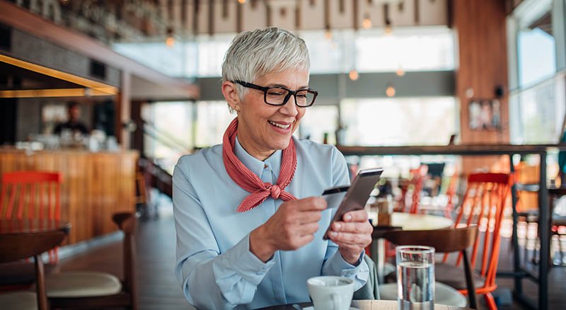 Woman using a card and smart phone